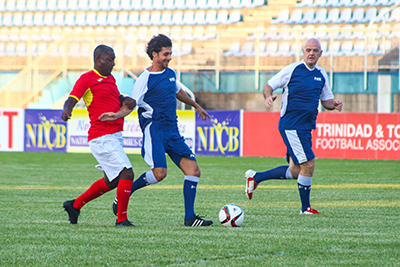 Pablo Aimar, centre, comes under challengefrom T&T's legend Russell Latapy with FIFA President Gianni Infantino providing support during Monday's Goodwill football match at the Ato Boldon Stadium in Couva. Photo by Nicholas Williams.