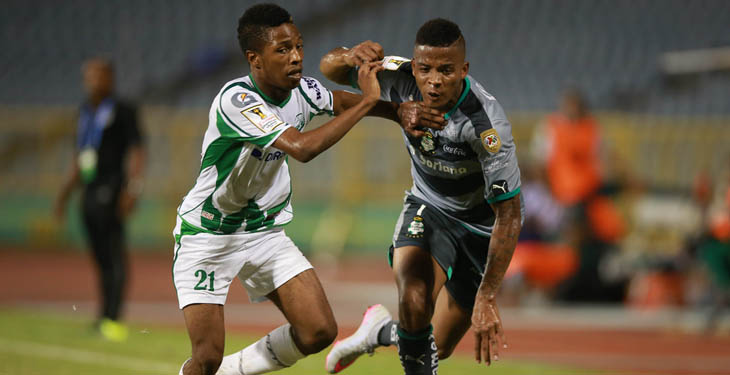 Santos's Andres Renteria tries to ward off DirecTV W Connection's Shannon Gomez (white jersey) during their Scotiabank CONCACAF Champions League game on September 22, 2015, in Port of Spain, Trinidad & Tobago. (Photo: Allan V. Crane)