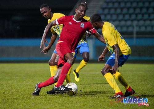 Photo: Cunupia FC attacker Kevon ‘Showtime’ Woodley (centre) tries to find a way past two Defence Force opponents during Pro League action at the Ato Boldon Stadium on 18 February 2020. (Copyright Daniel Prentice/Wired868)