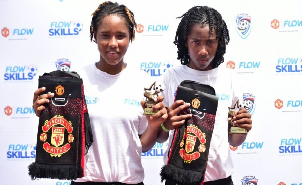 Winners: Female footballer, Moenesa Mejias (left) and 13-year-old, Molik Khan (right), pose with their Flow and ManU tokens at the Ato Boldon Stadium, Couva, yesterday.