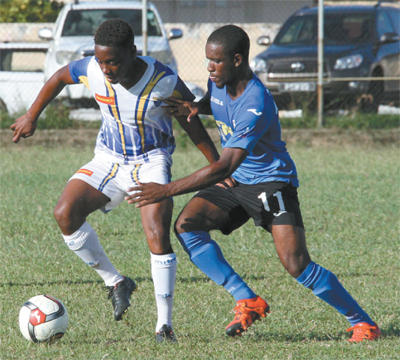Fatima College’s Krishorn Alexander, left, holds off a challenge from Shane Sandy of Naparima College in their 2015 BgTT/First Citizens Secondary Schools Football Premier Division League match at Fatima College Grounds, Mucurapo Road, yesterday. Naparima won 4-1. Photo: Anthony Harris.