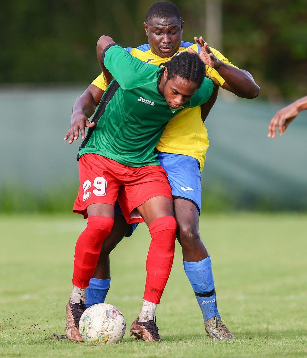 San Juan Jabloteh's Elijah Seechan (green shirt) screens off the Defence Force II FC defender Trevin Latapy to maintain possession during the T&T Premier Football League Knockout Cup preliminary match between at the Phase II Recreation Grounds in La Horquetta on Wednesday. San Juan Jabloteh won 2-1. (Photo by Daniel Prentice)