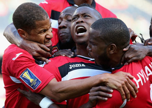 Photo: Trinidad and Tobago defender Sheldon Bateau (centre) celebrates the opening goal against Guatemala with teammates Radanfah Abu Bakr (left) and Khaleem Hyland during their 3-1 win at the 2015 Gold Cup. (Copyright Jonathan Daniel/AFP 2015)