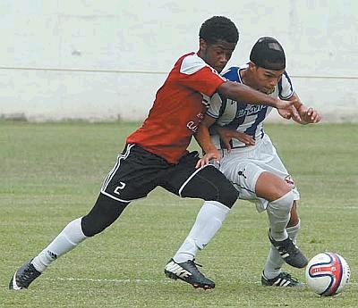 Ethan Shim, right, tries to muscle his way past Jared Flament of St AnthonyÂ’s College during a Secondary Schools Football League (SSFL) Premier Division clash yesterday. Shim scored in the first half as St MaryÂ’s won the contest 1-0, on home turf, to help Naparima College move to the top of the standings, while moving St AnthonyÂ’s into second. Photo: Anthony Harris