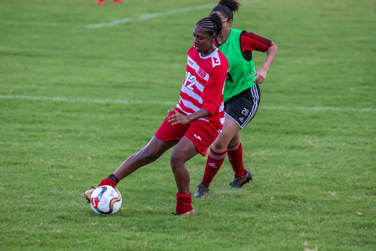 UTT’s Tracy Smith,left, dribbles past a Central Women player, during the TT Women’s Football League match, at UTT O’Meara, on Saturday. UTT won the match 20-0.