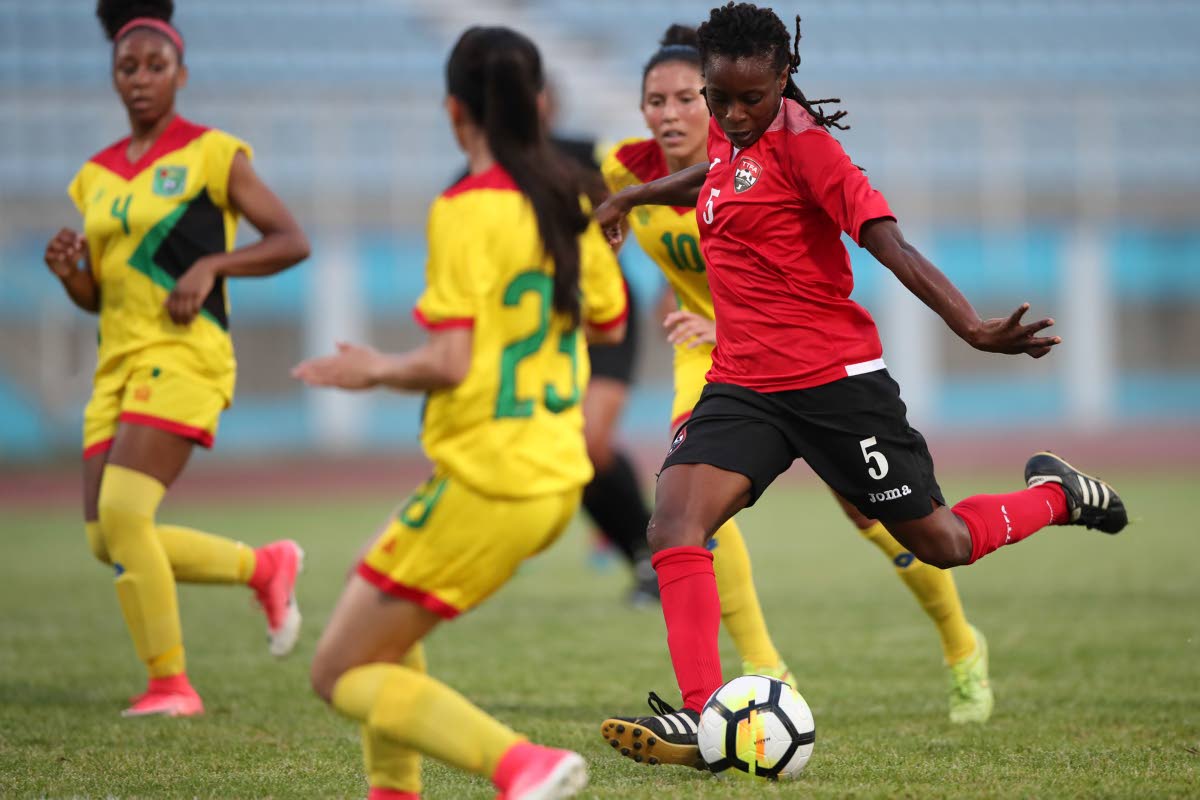 T&T’s Jenelle Cunningham (#5) has a shot on goal between Guyana defenders Nailah Rowe (#4) Rylee Traicoff (#23) and Mariam El-Masri (#10), during the CFU Women’s Challenger Series 2018 between TT (red) and Guyana (yellow) at the Ato Boldon Stadium, Couva, yesterday.
