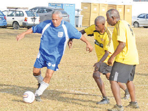 Rolling back the years: Former Mayor of Port of Spain and Belmont Secondary footballer Louis Lee Sing, left, is shadowed by Tranquillity SecondaryÂ’s Jerome Lewis, second from right, and David Kwame during their Intercol Nostalgia Football Festival match at the St MaryÂ’s College Grounds, Serpentine Road on Saturday. Â—Photo: Ishmael Salandy