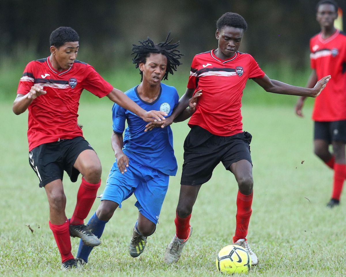 Arima North Secondary’s Nicholas Torres, centre, tries to bulldoze his way through two Five Rivers Secondary midfielders during the Secondary School Football League Championship match at the Arima North Secondary ground Friday, October 7th 2022 in Arima. Arima North won 4-1. PHOTO: Daniel Prentice