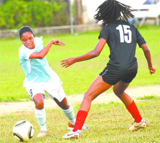 LUCKY BATTLE: Real Dimension's Racine Romain, left, takes on Arima Giants defender Akeisha Lester during a Lucky Bakery Women's Football League match at Barataria Oval. Real Dimension won 8-1. –Photo: Anisto Alves.