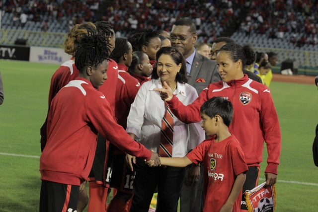 Prime Minister Kamla Persad-Bissessar greets T&TÂ’s Women footballers before their game against Ecuador
