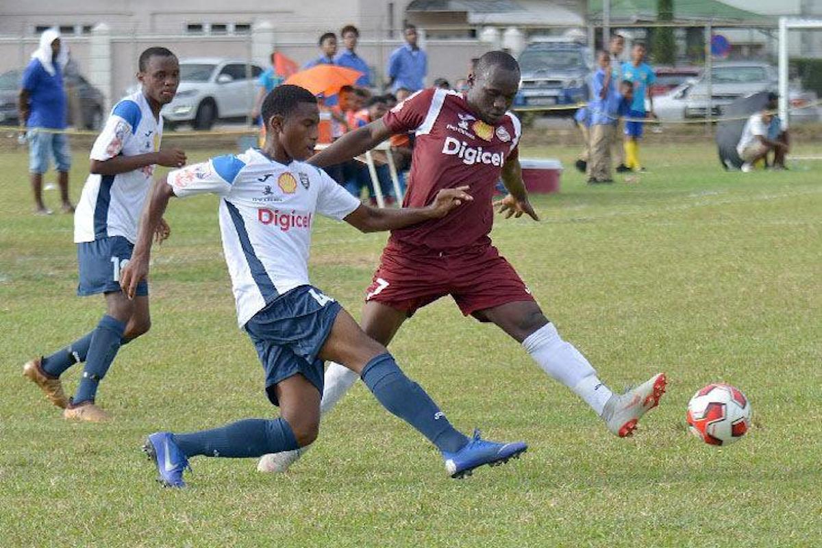 THE WAY THEY WERE: Mucurapo Secondary’s Jaheim Patrick, right, and Ezekiel Armstrong of Queen’s Royal College during Secondary Schools Football League Premier Division action in 2019.