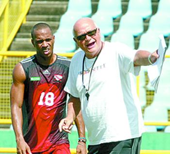 Midfielder Densill Theobald, right, exchange ideas with coach Otto Pfister during the team’s final training session at Hasely Crawford Stadium, Mucurapo yesterday. Photo: Anthony Harris 