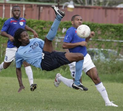 Queen’s Park CC’s Dexter Franklyn, centre, attempts a bicycle-kick under pressure from WASA’s Fabian Garcia in their bmobile National Super League encounter at the Hasely Crawford Stadium, Training Field, Mucurapo, yesterday. WASA won 2-1. Photo: Anthony Harris