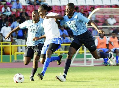 ﻿Ryan Frederick of Naparima beats Jumaane Cox, left, and Jeroen Blugh of Queen’s Royal College to the ball during action in the Coca Cola InterCol quarterfinals yesterday at Hasely Crawford Stadium. Naparima won the game. (Photo Credit: T&T Guardian).