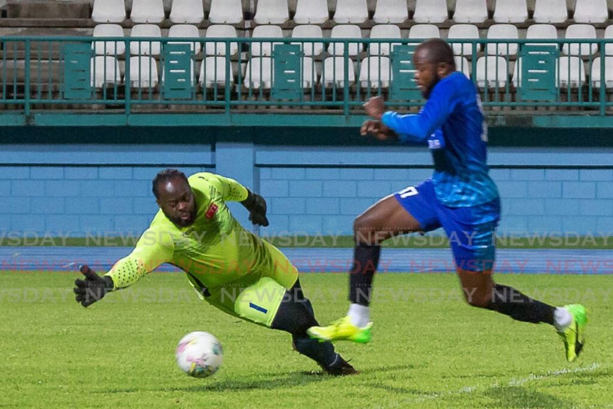 Sidey's Pavel Warrick looks to dribble around the Roxborough Lakers goalie Learie McKenzie in their Tobago Ascension Premier League match on Friday, August 26th 2022 at the Dwight Yorke Stadium, Bacolet. PHOTO: David Reid