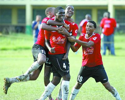St Anthony’s College captain, Dwight Ceballo, second from left, is mobbed by team-mates, Rayshard Allen, Jemali Garcia and Jonathan Cruickshank after scoring against Trinity in their BG T&T North Zone Secondary Schools Football League match at St Anthony’s College Ground, Westmoorings, on Wednesday. St Anthony’s won 4-0. Photo: Anthony Harris