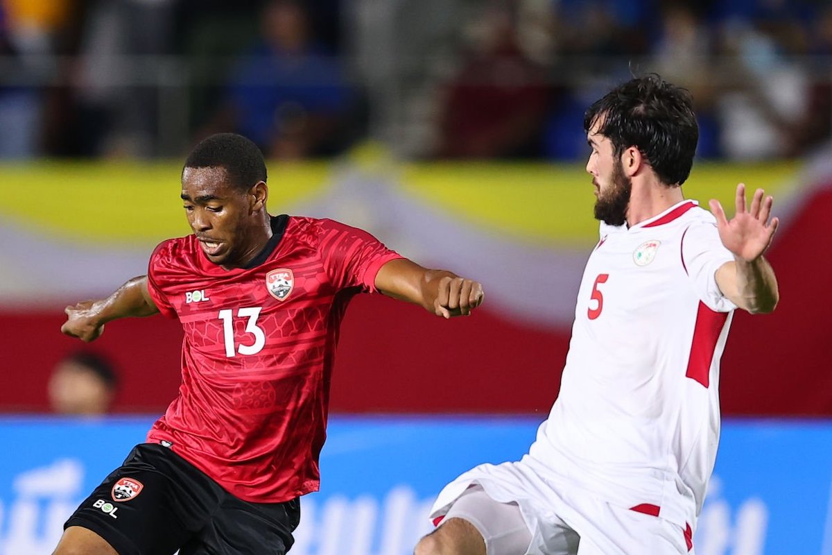 Reon Moore of Trinidad and Tobago (C) controls the ball under pressure of Manuchehr Safarov of Tajikistan (R) during the international friendly match between Trinidad and Tobago and Tajikistan at 700th Anniversary Stadium on September 22, 2022 in Chiang Mai, Thailand. (Photo by Pakawich Damrongkiattisak/Getty Images)