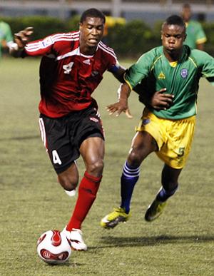 T&T captain, Sheldon Bateau, left, goes past St Vincent and The Grenadines’ Nical Stephens in their Caribbean Football Union Under-20 Group D qualifier at the Marvin Lee Stadium, Macoya on Wednesday night. T&T won 4-1. ...Photo: Anthony Harris.