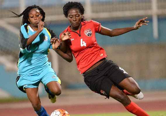 RACE ON: T&T’s Daniela Findley, right, vies for possession with St Lucia’s Joanne Alphonse during action from Friday night’s CFU Olympic qualifier clash at the Ato Boldon Stadium, Couva. T&T shutout their Caribbean rivals 6-0. — Photo: DEXTER PHILIP