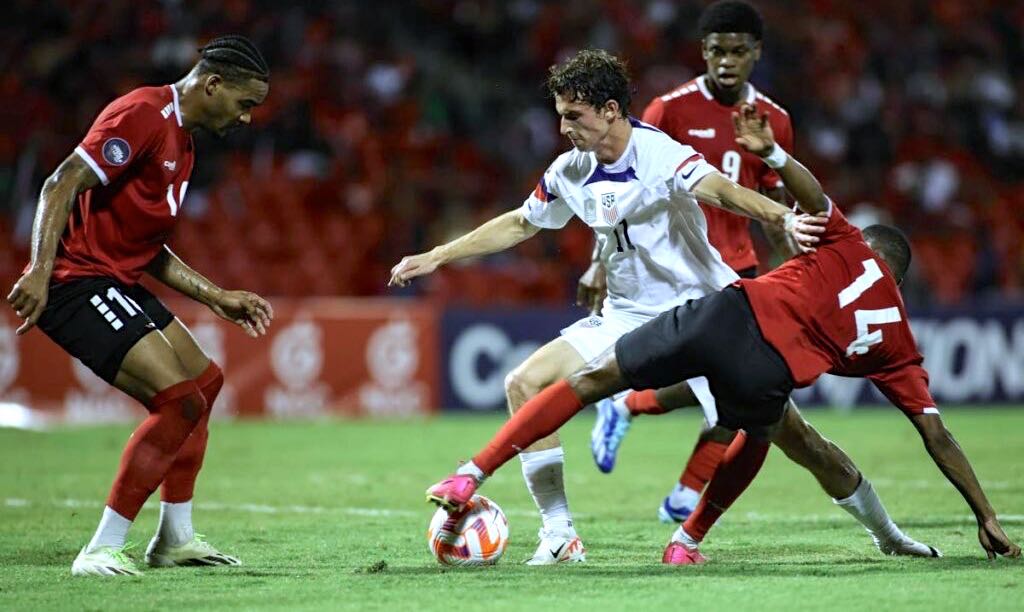 United States' Brenden Aaronson (C) fights for the ball with T&T's Shannon Gomez (R) and Alvin Jones (L) during a Concacaf Nations League quarterfinal match, at the Hasely Crawford Stadium, Port of Spain,on Monday - AP PHOTO.