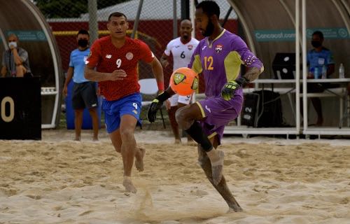 Photo: Trinidad and Tobago goalkeeper Zane Coker (right) weighs up his options while Costa Rica forward Greivin Pacheco closes in during 2021 Concacaf Beach Soccer Championship action at the Complejo Deportivo Fedefutbol, Alajuela, Costa Rica. (Photo: Concacaf/Straffon Images/Alexander Otalora)