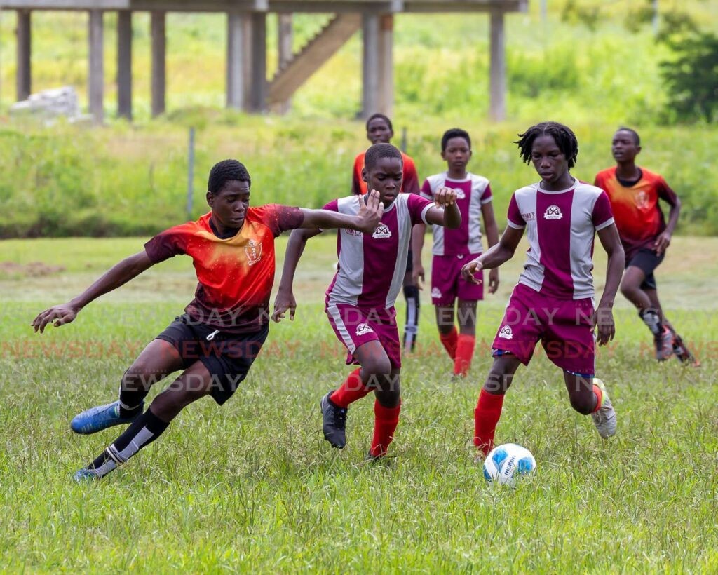 I’zea Phillip, left, of Bon Accord Primary School,vies for the ball with players of the St Andrew’s Anglican Primary School during the Tobago Primary Schools Under 15 Football League semi-final match, at Black Rock Recreation Grounds Corland, Tobago on Monday. - David Reid