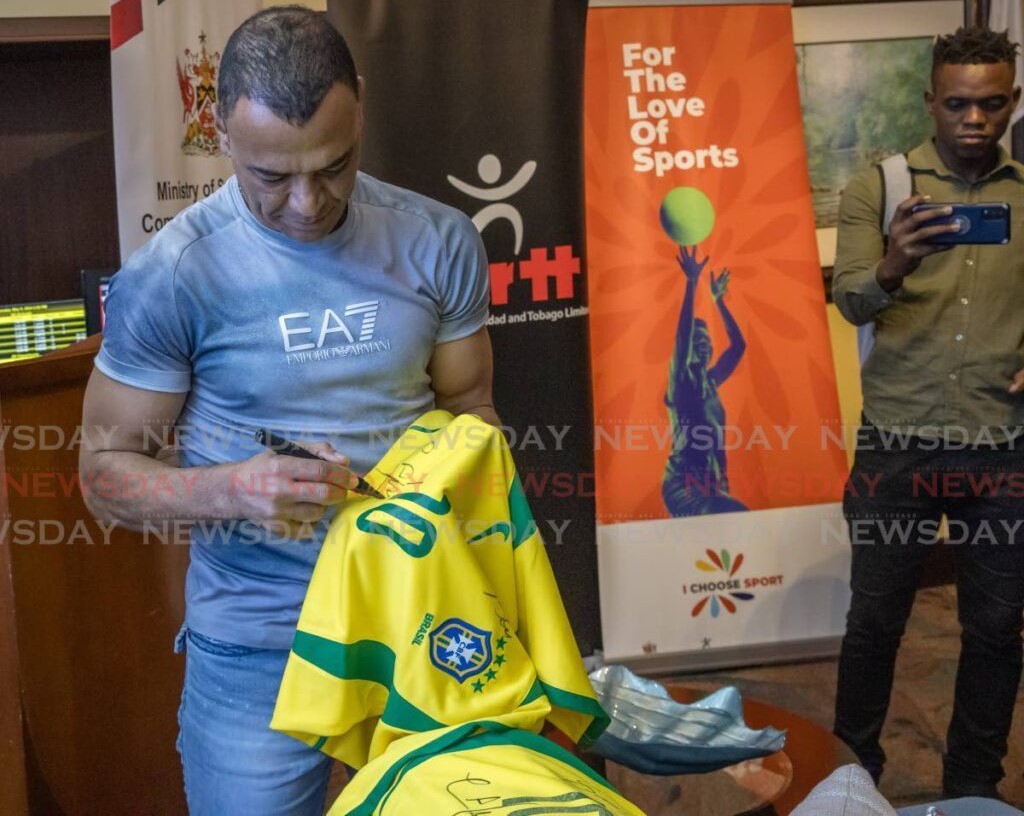 Brazil's Fifa 2002 World Cup winner Cafu signs a Brazil jersey at the Piarco International Airport on May 9 ahead of the Legends of football match at the Hasely Crawford Stadium on May 10. - Photo by Jeff K Mayers