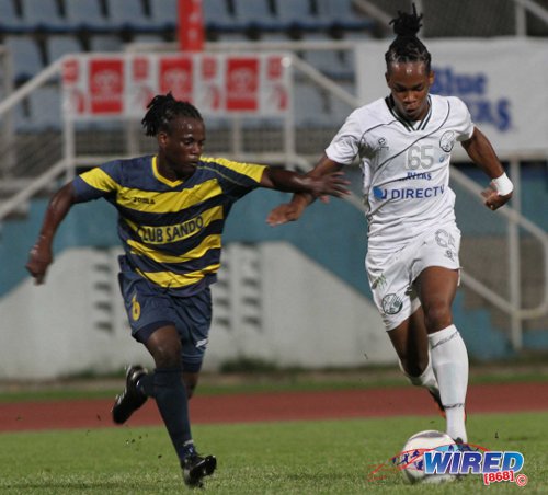Photo: W Connection attacker Neil Benjamin Jr (right) runs at Club Sando fullback Kemuel Rivers during the 2013 Toyota Cup. (Courtesy Allan V Crane/Wired868)
