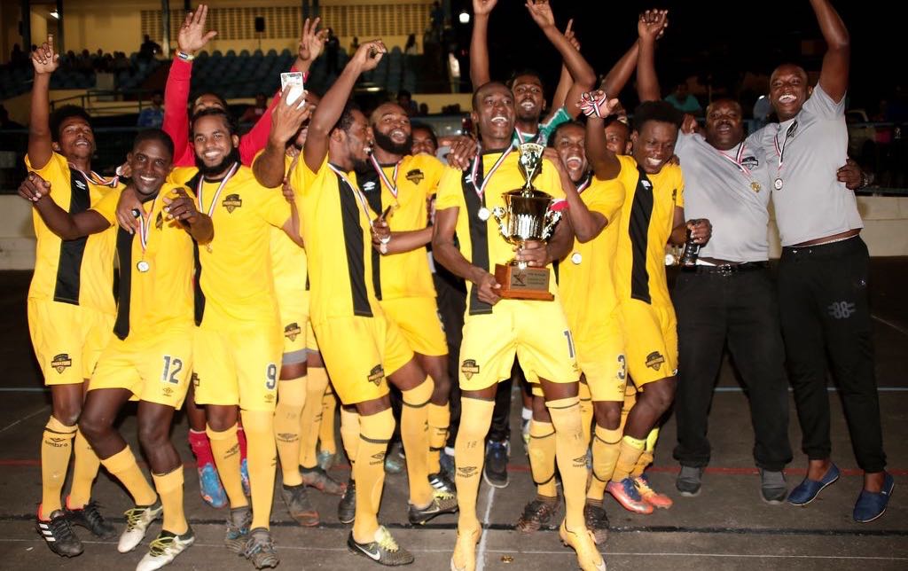 Members of Cunupia FC celebrate after winning the T&T Super League Cup final against rival Queen’s Park Cricket Club at the Arima Municipal Stadium on Sunday night.