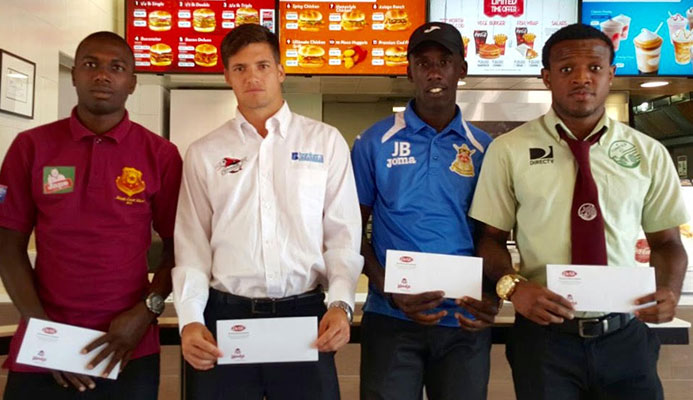 Left to right: North East Stars' Keron Cummings, Central FC's Sean De Silva, Defence Force's Jerwyn Balthazar and W Connection's Jomal Williams display their Wendy’s Player of the Month vouchers on Feb. 22 at Wendy's Ariapita Avenue restaurant in Woodbrook, Port of Spain.