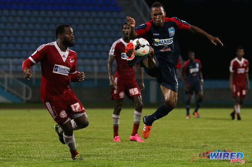Photo: Morvant Caledonia United midfielder Densill Theobald (right) controls the ball while Central FC defender Marcelle Francois looks on during 2015 Toyota Classic quarterfinal action. (Courtesy Chevaughn Christopher/Wired868)