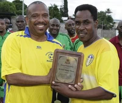 Earl "Mango" Pierre, left, presents an award to former national footballer Ron La Forest at a past function. -