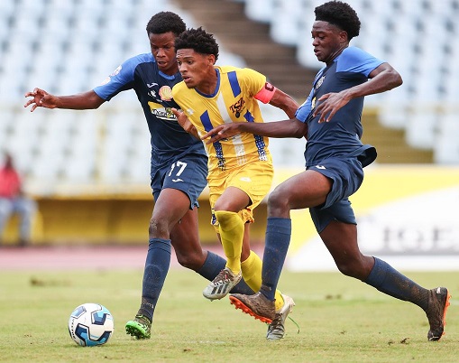 Fatima's captain and attacker Christian Bailey, centre, powers his way through Queens Royal College defence of Nicholas Thompson, right, and Zakari King during the Secondary School Football League North Zone Intercol Final at the Hasely Crawford Stadium in Mucurapo, Port-of-Spain. Bailey scored one goal in Fatima 5-0 win. (Photo by Daniel Prentice)