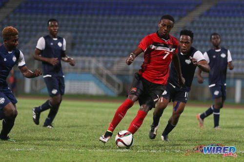 Photo: Trinidad and Tobago National Under-20 winger Isaiah Hudson (centre) runs at the Turks and Caicos defence during Caribbean Cup qualifying action at the Ato Boldon Stadium on 17 June 2016. T&T won 11-0.... (Courtesy Chevaughn Christopher/Wired868)