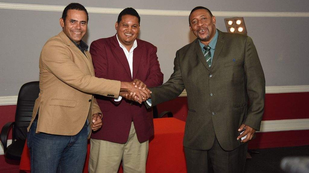 UNITED: Minister of Sport Darryl Smith, centre, joins hands with Michael Phillips, left, new chairman of SPORTT, and David John-Williams, new TTFA president, at the Ministry of Sport and Youth Affairs yesterday. —Photo: Ayanna Kinsale