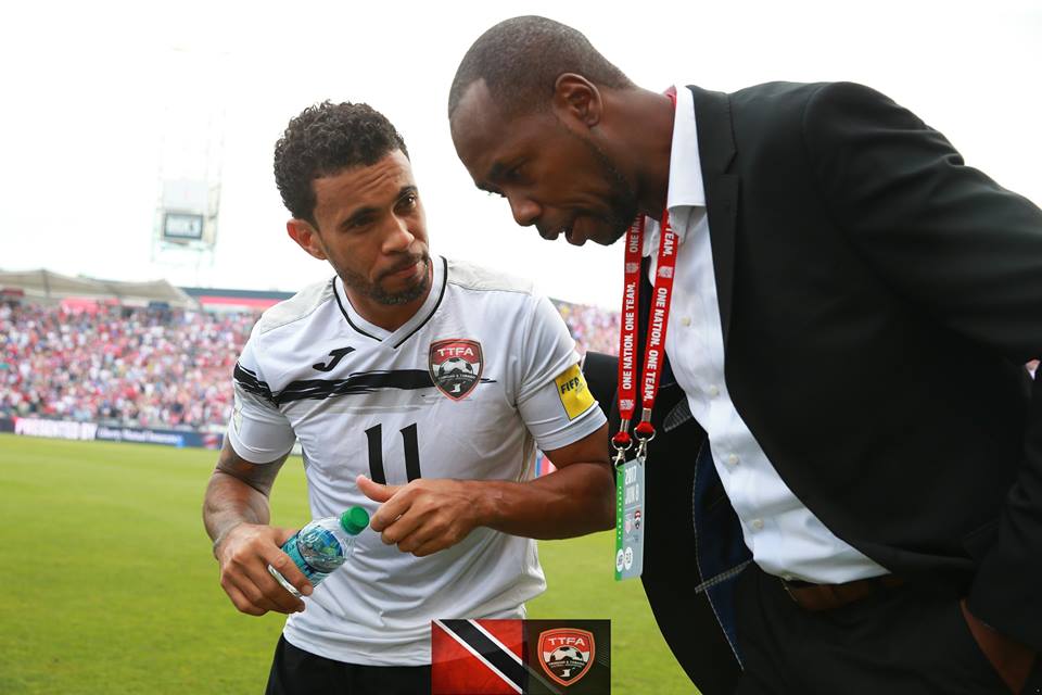 Coach Dennis Lawrence and former teammate Carlos Edwards having a conversation during a T&T match.