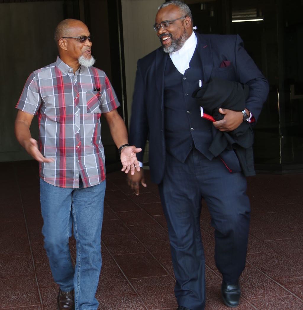 T&T Super League president, Keith Look Loy, left, with his attorney Matthew Gayle leaves Hall of Justice in Port-of-Spain after winning his case against the T&T Football Association (TTFA), yesterday.