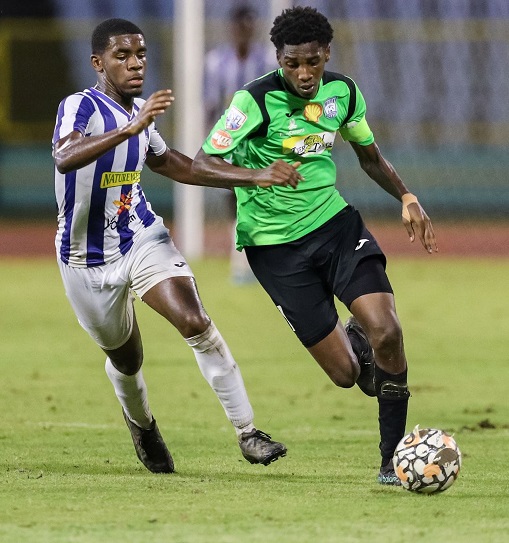 Malick Secondary captain Lendelle Baptiste, right, goes past St Mary's College defender Marley Callendar during the Secondary School Football League’s Intercol match at the Hasely Crawford Stadium in Port-of-Spain, yesterday. Malick won 3-1. (Photo by Daniel Prentice)