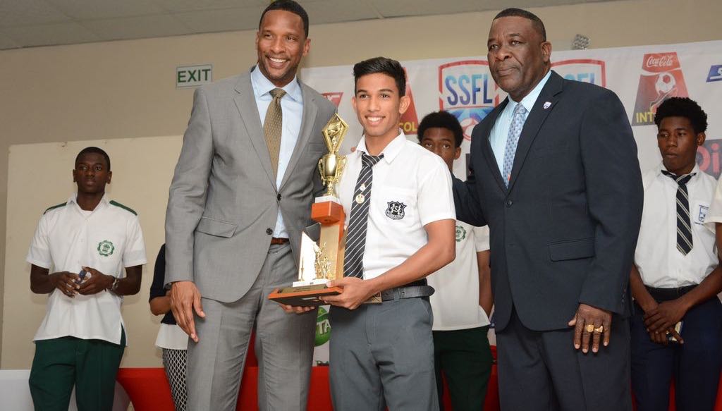 Shaka Hislop, left, and president of SSFL William Wallace present the boys’ “Player of the Year” trophy to Mark Ramdeen of Naparima College during the awards function, yesterday.