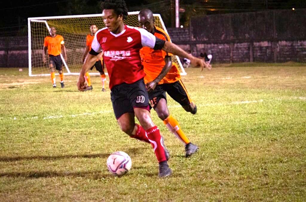 A Mayaro Utd player (red t-shirt), tries to stay ahead of a Cool It player during action on the opening night of the Sweet Sixteen Football League at the Ojoe Road Recreational Grounds in Sangre Grande, on April 30. - Sweet Sixteen Football League Facebook page