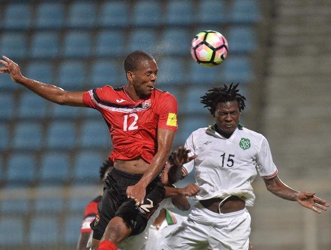 Trinidad and Tobago’s Carlyle Mitchell, left, rises above Suriname’s Miquel Darson while contesting a header during action from last night’s clash, in the Caribbean 5th-place qualifying series for a berth in this year’s CONCACAF Gold Cup, at the Ato Boldon Stadium in Couva. Suriname won the match 2-1 in extra time. —Photo: DEXTER PHILIP