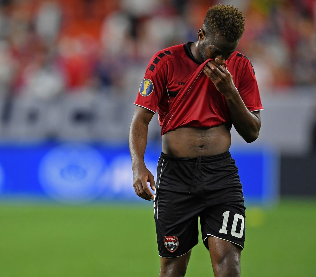 T&T midfielder Kevin Molino walks off the field after the team's 6-0 loss to the United States in a CONCACAF Gold Cup football match Saturday in Cleveland. (AP)