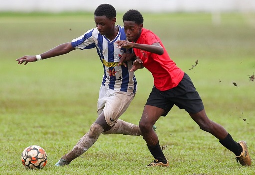 St Mary's College attacker Josiah Connell, left, holds off the strong challenge Mucurapo West Secondary's Reece Baptiste during the Secondary School Football League Championship match at St Mary's College Ground, Serpentine Road, St Clair in Port-of-Spain on Tuesday. St Mary's College won 4-1. (Photo by Daniel Prentice)