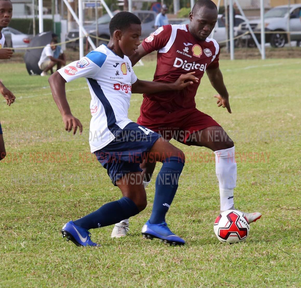 Mucurapo East’s Jaheim Patrick,right, and Queen’s Royal College’s Ezekiel Armstrong battle for the ball in the SSFL opener,at Fatima Grounds, Mucurapo. PHOTO BY SUREASH CHOLAI