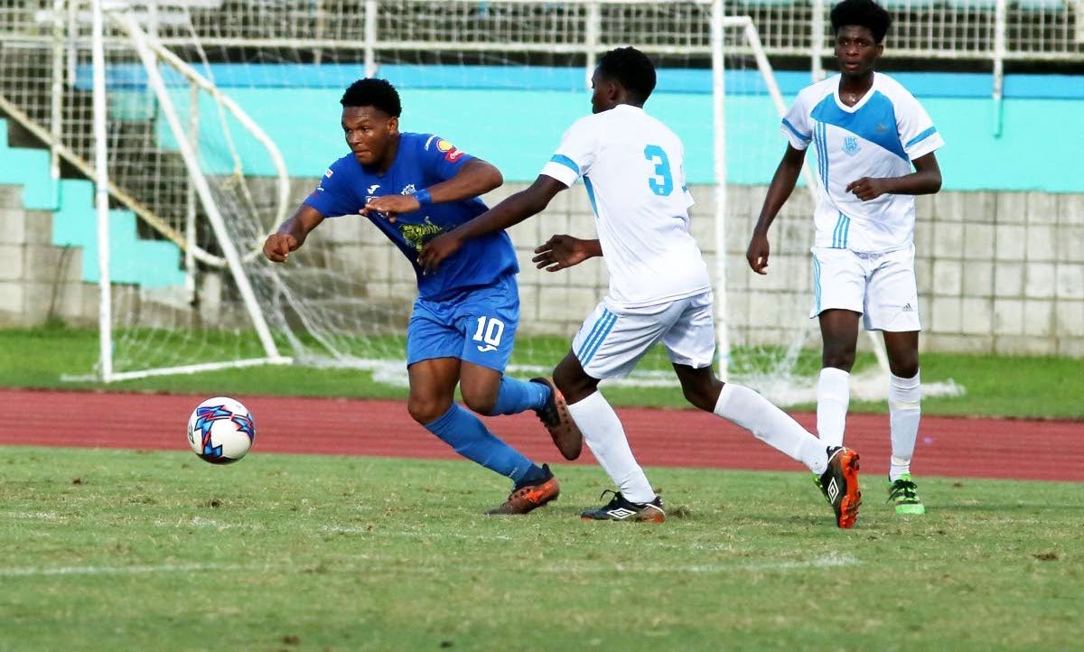 Naparima College’s Decklan Marcelle(10) evades two La Romaine players during action in the South Zone, Secondary Schools Intercol quarterfinal match, at the Manny Ramjohn Stadium,Marabella, yesterday.