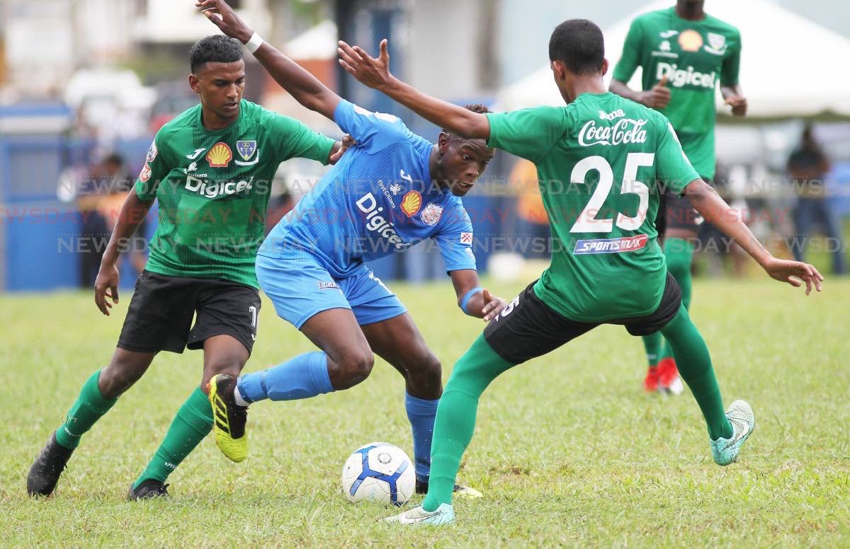 Naparima College player Decklan Marcelle (C) tries to evade Symron Wiseman(R) of St Bendict's College,during the Secondary Schools Football League match,held at Lewis Street, San Fernando,yesterday.
