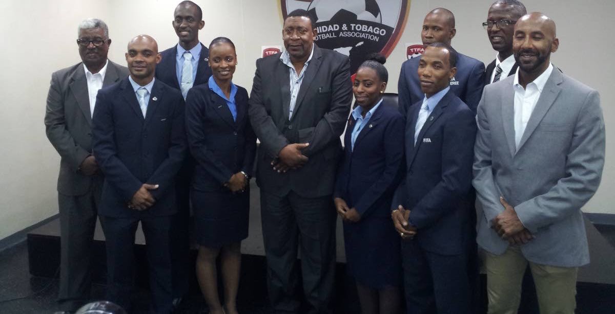 President of the TT Football Association David John-Williams, fifth from left, along with local referees and local referee administrators at the Ato Boldon Stadium in Couva, yesterday. Seven local referees received FIFA badges yesterday.