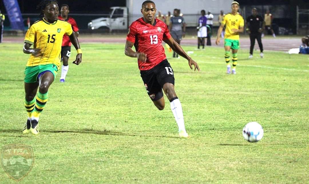 Moore (#13) against Jamaica's Oshana Staple (#15) gives Soca Warriors 1-0 edge vs Jamaica.