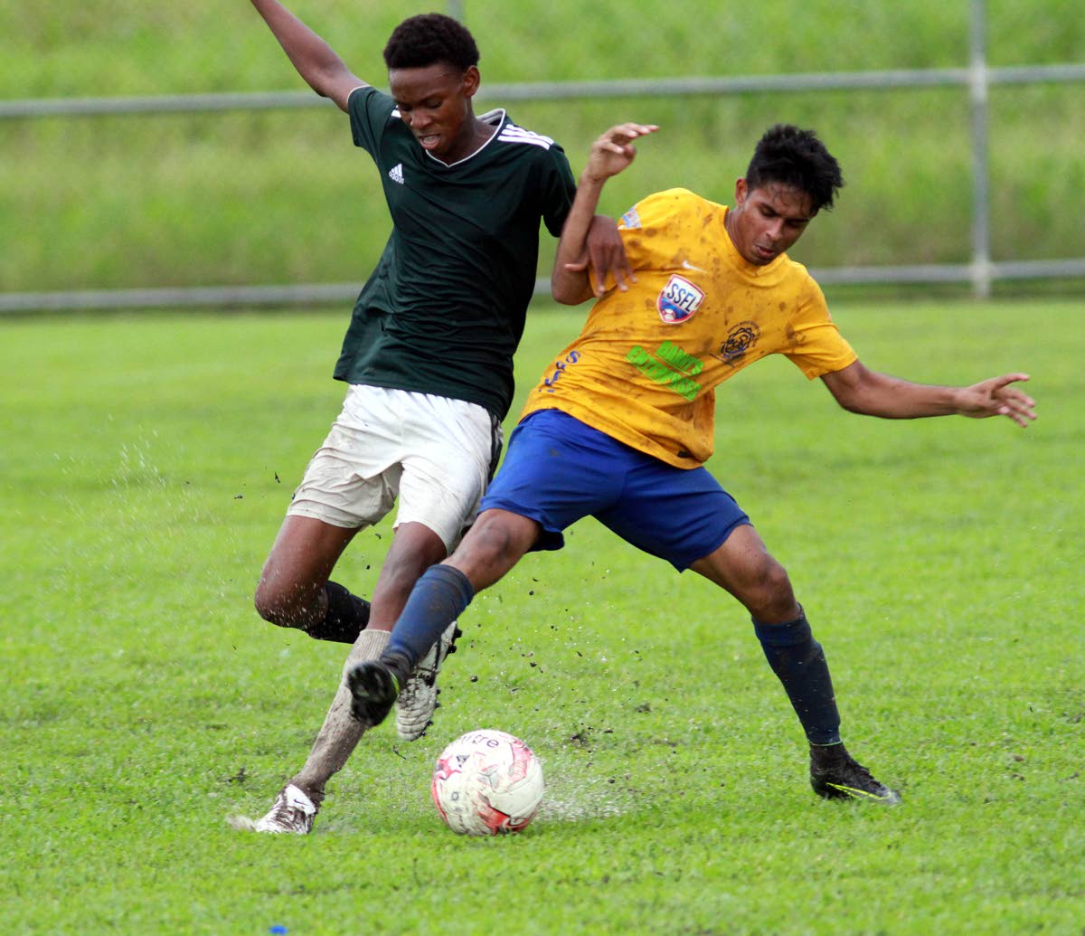 A Shiva Boys’ player battles with his opponent from Rio Claro West during a SSFL South Zone Under-20 match on Friday at the Manny Ramjohn Stadium Training Ground, Marabella.