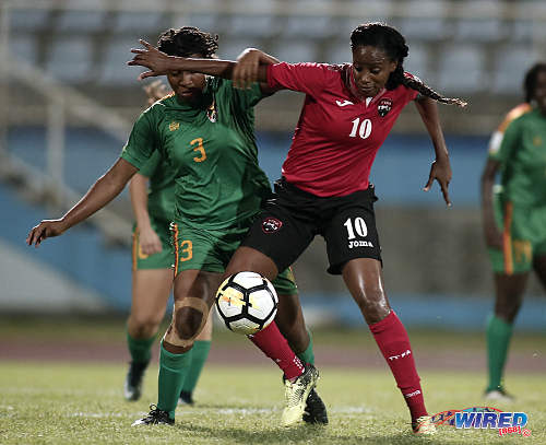 Photo: Trinidad and Tobago captain Tasha St Louis (right) holds off Grenada defender Treasher Valcin during 2019 World Cup qualifying action at the Ato Boldon Stadium on 27 May 2018. (Copyright Chevaughn Christopher/Wired868)